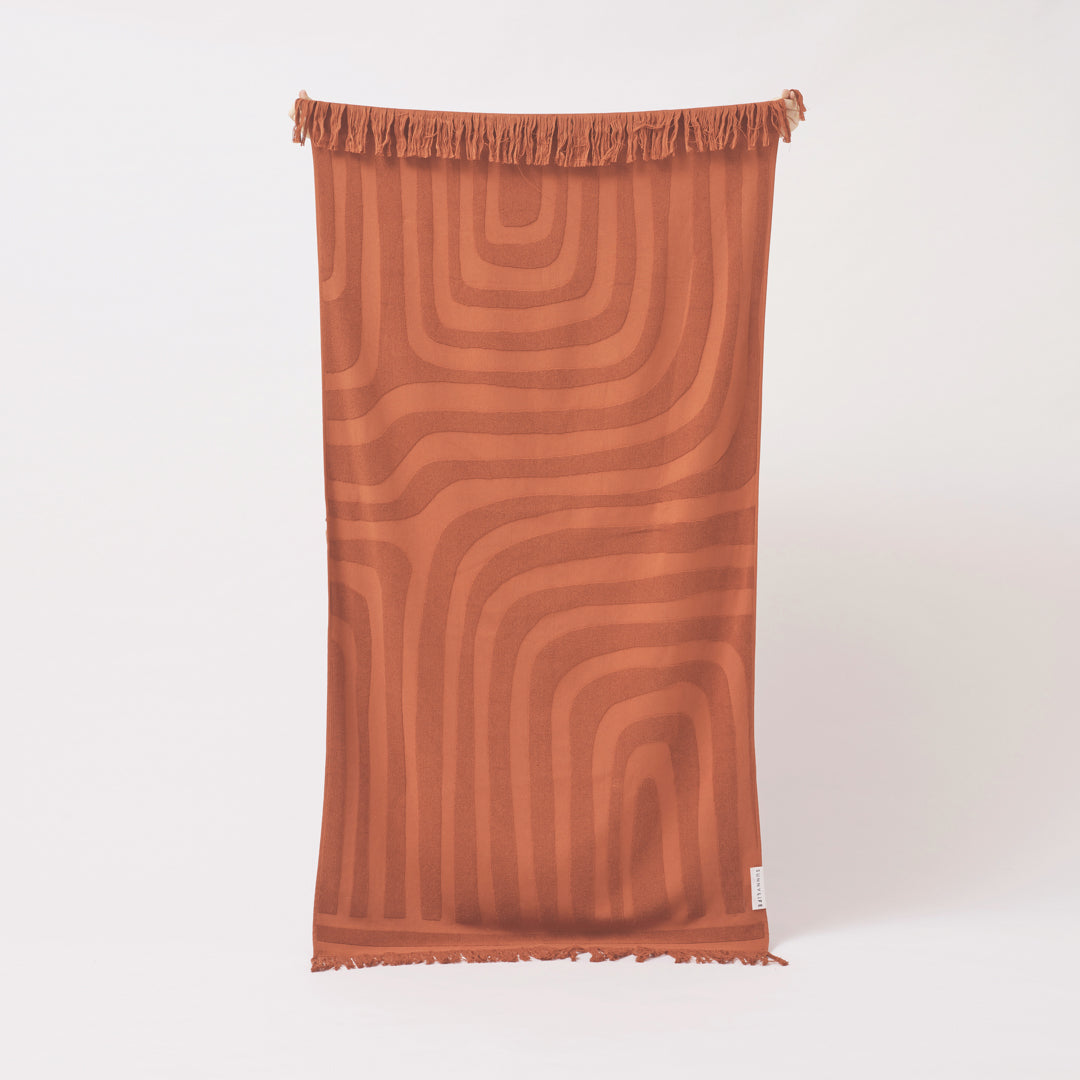 SUNNYLiFE Luxe Beach Towel in terracotta orange colour made from premium 420gsm Jacquard cotton terry towelling at Inner Beach Co, Toronto, Canada