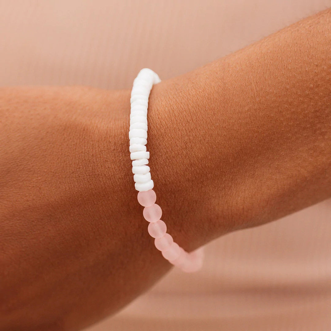 Pura Vida Puka Shell & Frosted Bead Stretch Bracelet in Pink features natural puka shell beads and bright frosted beads at Inner Beach Co, Toronto, Ontario, Canada