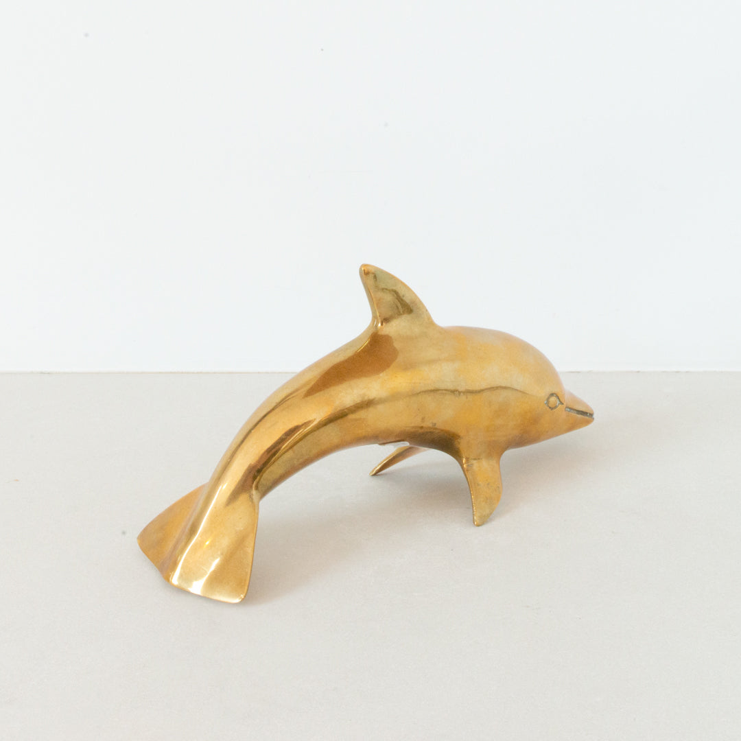 Vintage polished brass dolphin figurine at Inner Beach Co, Toronto, Canada