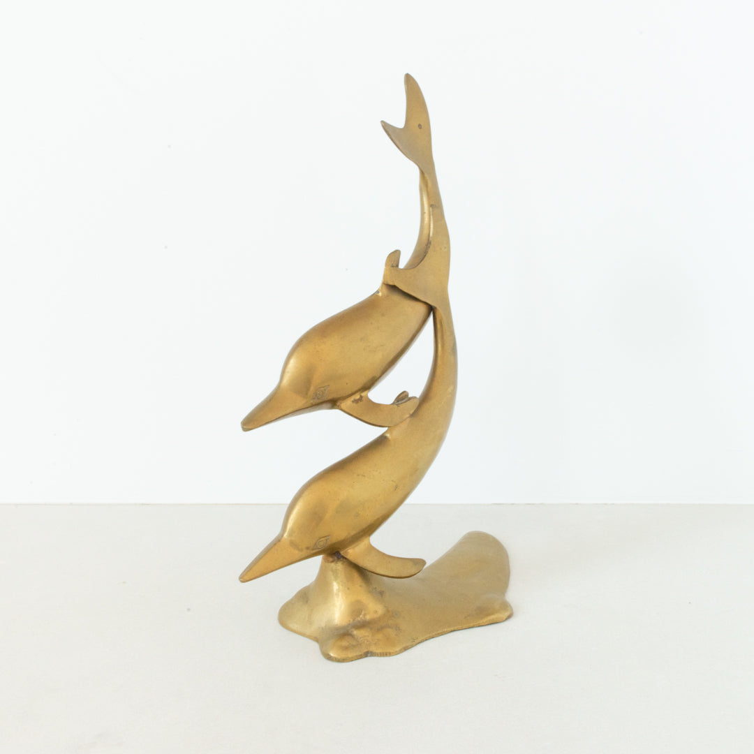 Vintage brass figurine depicting a pair of dolphins playing in the surf at Inner Beach Co, Toronto, Canada
