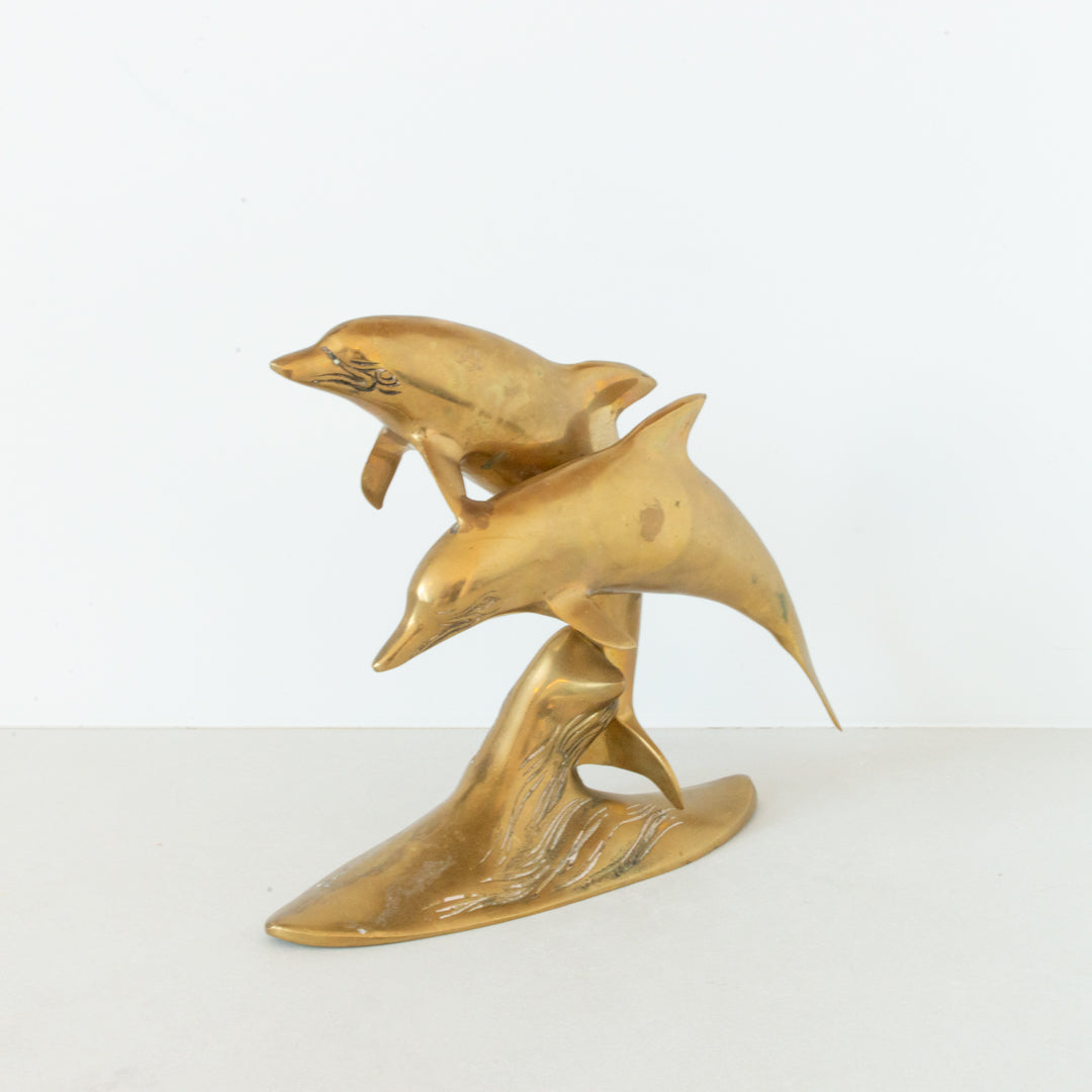 Vintage brass figurine depicting a pair of dolphins playing in the surf available at Inner Beach Co, Toronto, Canada