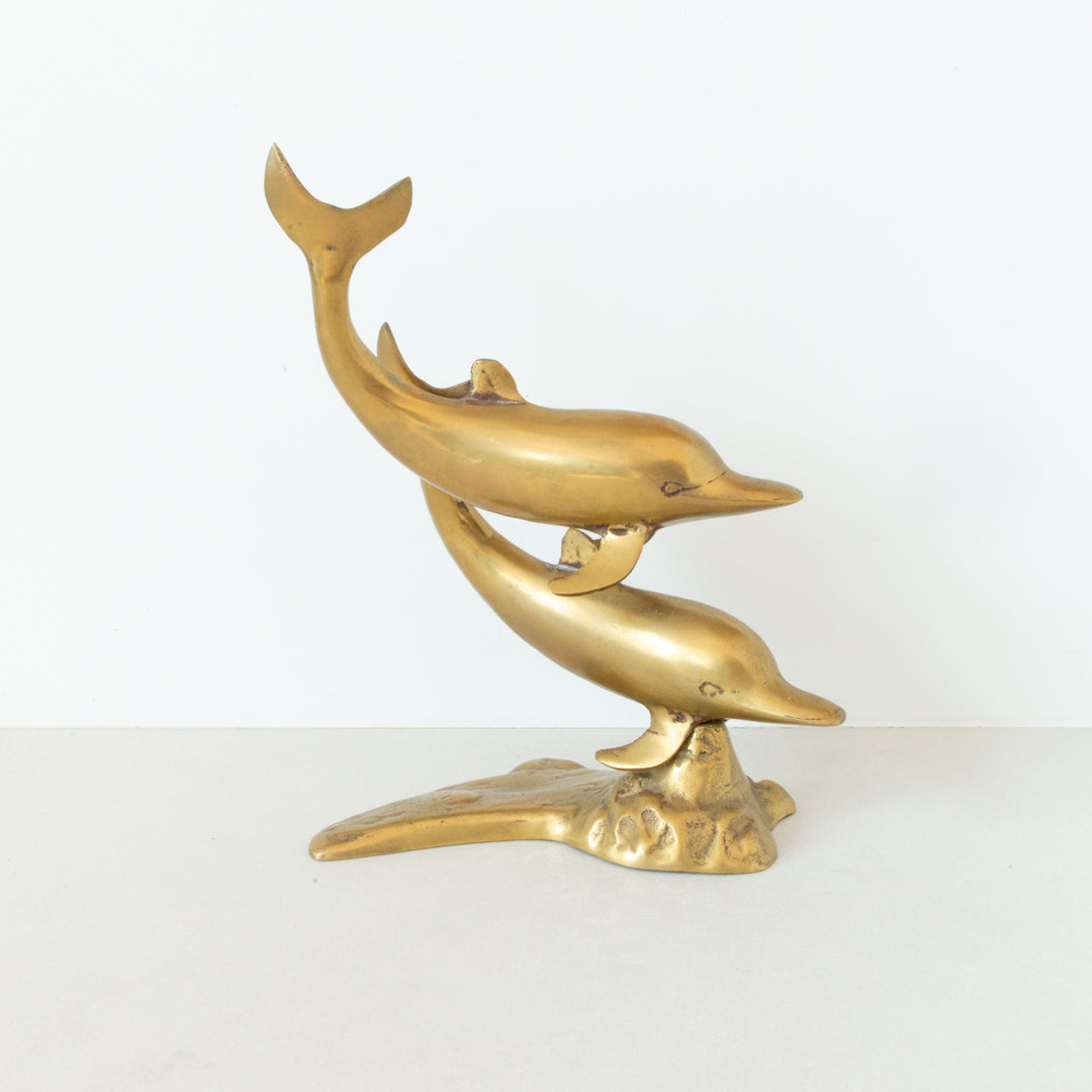 Vintage brass figurine depicting a pair of dolphins playing in the surf available at Inner Beach Co, Toronto, Canada