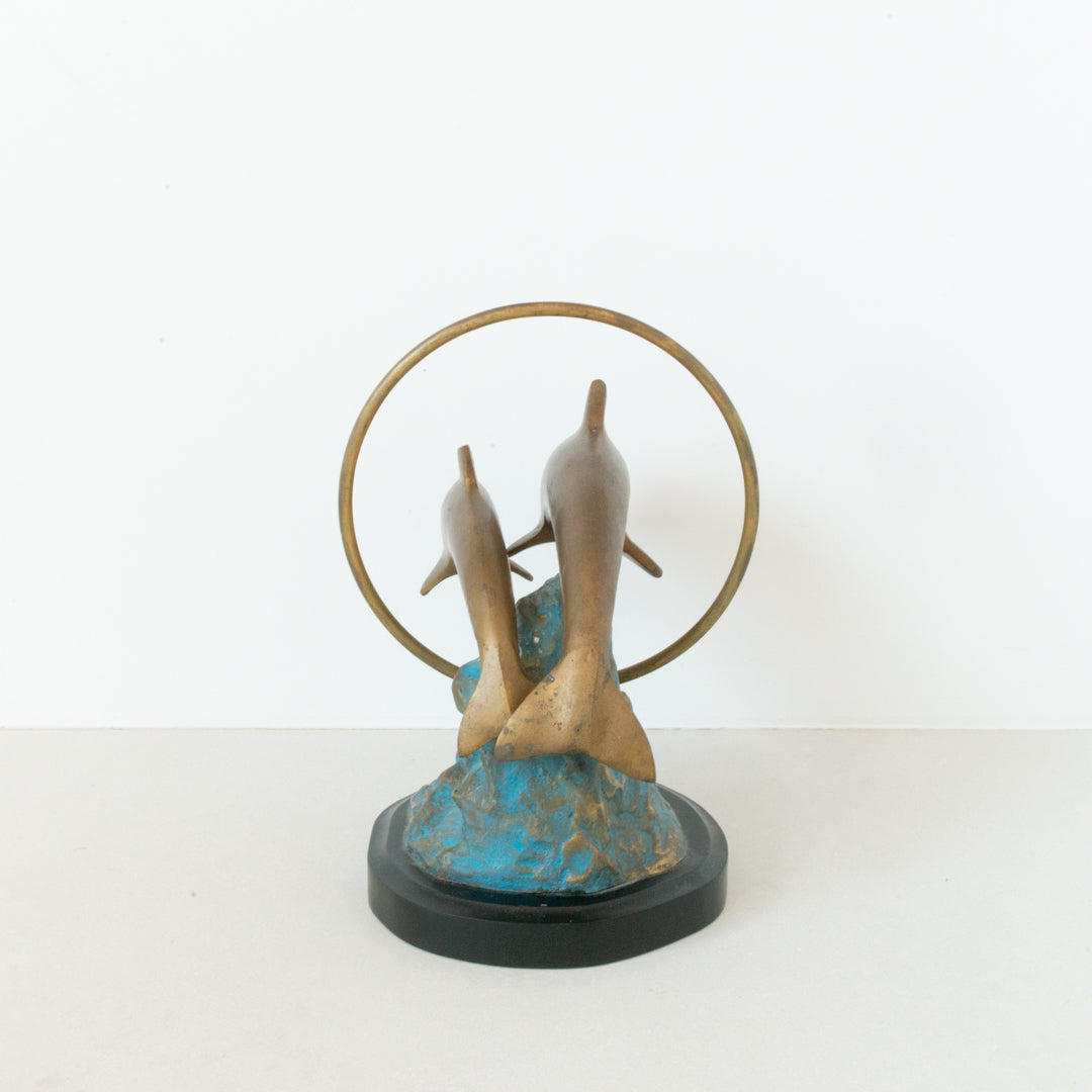 Vintage brass figurine depicting a pair of dolphins jumping through a hoop available at Inner Beach Co, Toronto, Canada